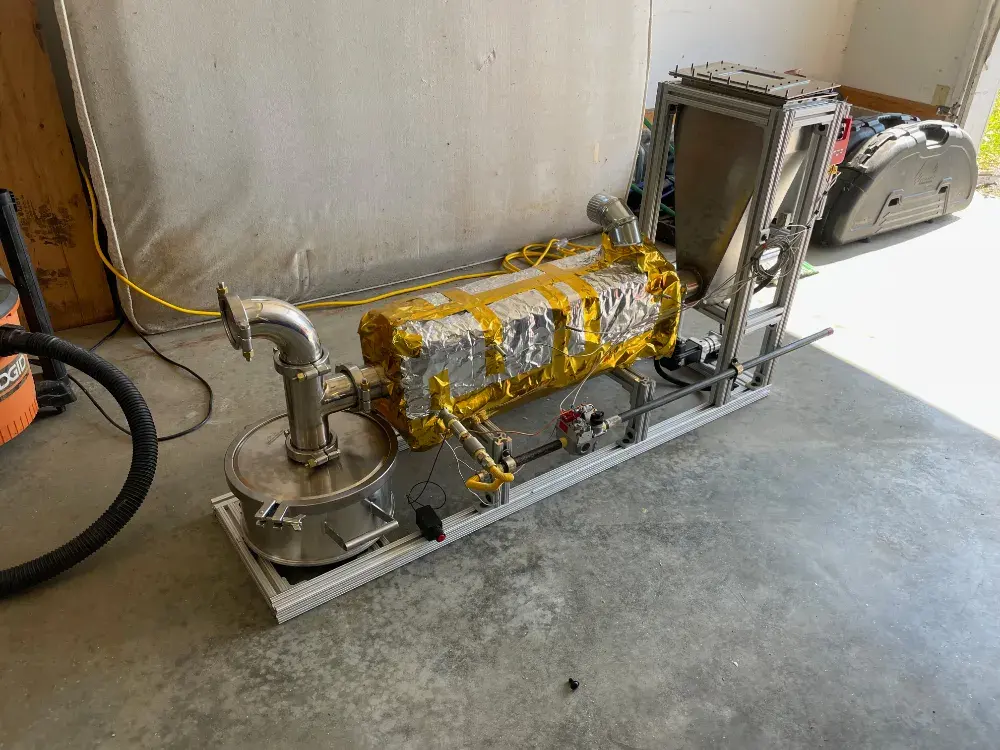 Generation 02 prototype — stainless steel reactor on extruded aluminum frame with HMI and emergency stop